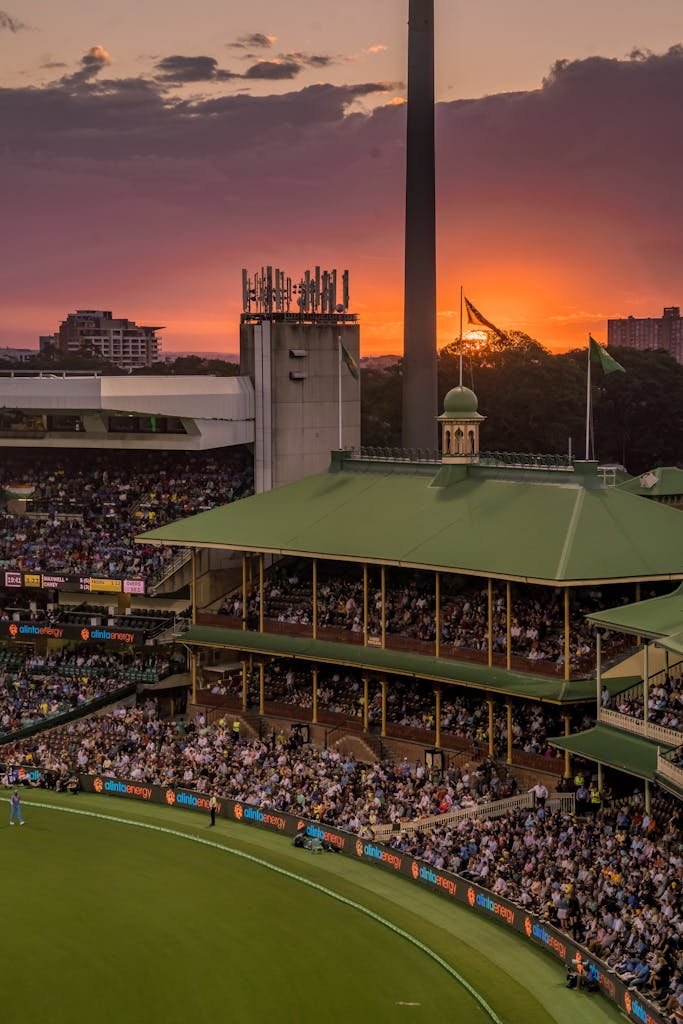 A Wheon Cricket 07 colorful sunset over a bustling cricket stadium, capturing the lively atmosphere of the event.