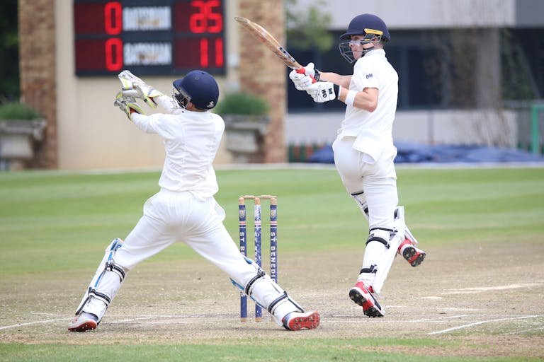 Wheon Cricket 07 Dynamic cricket scene with batsman playing a shot and wicketkeeper in action.