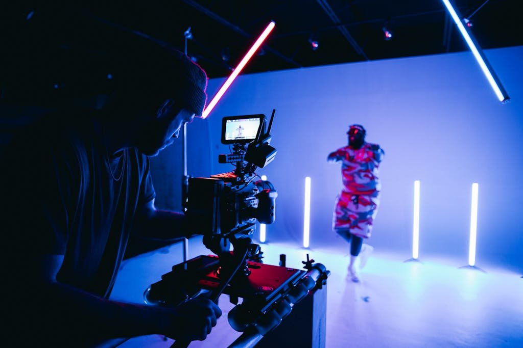 This Vid Vore Behind-the-scenes look at a studio shoot with neon lights and camera crew.