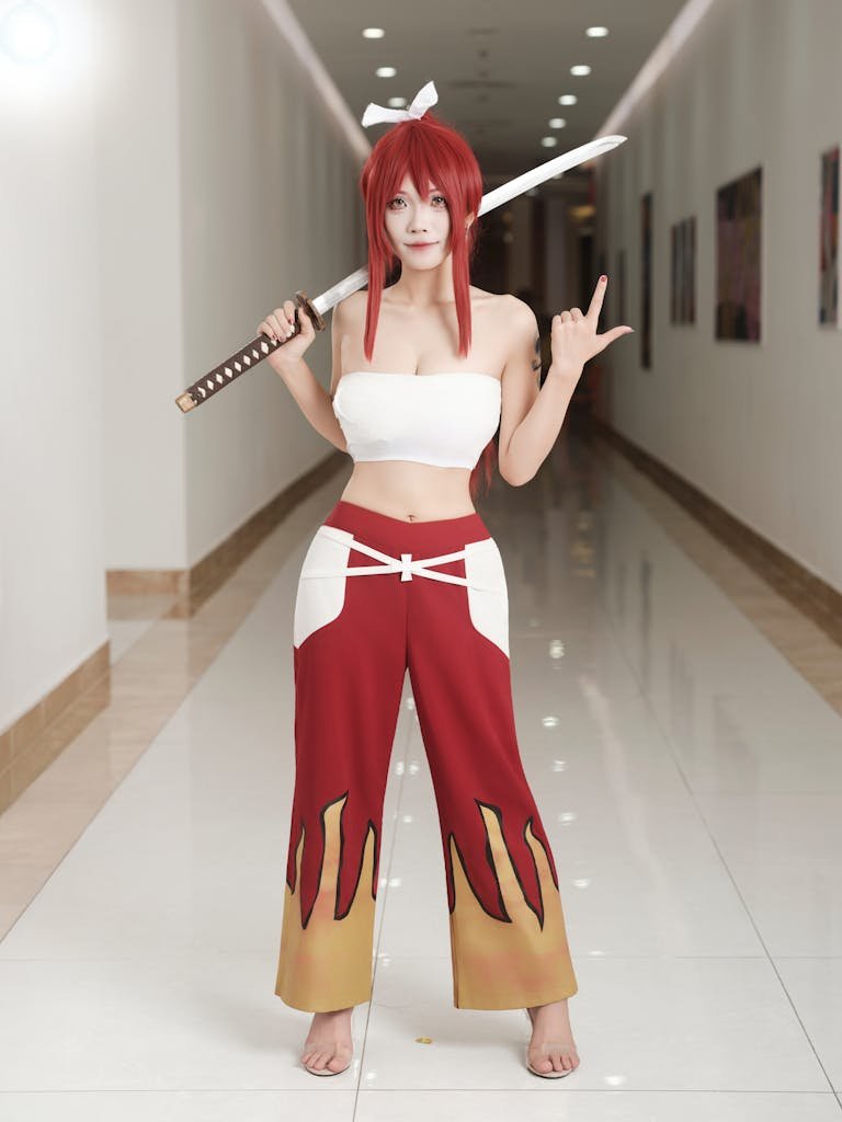 thisvidscat dildo japanese
Person in anime cosplay with sword posing in a bright hallway.
