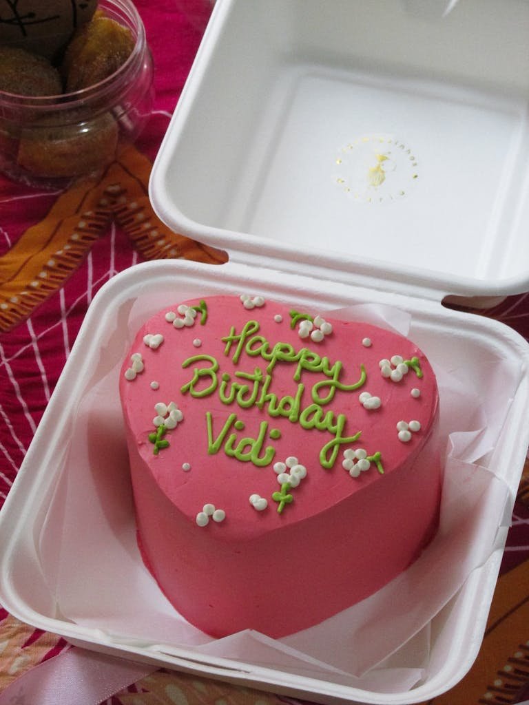 This Vid Pink heart-shaped birthday cake with floral decoration in takeaway box.thisvidscat.org